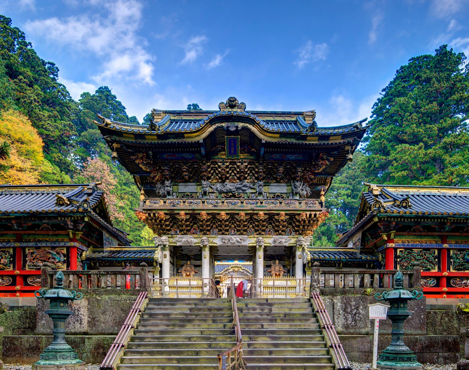 Nikko, Japan - November 1, 2012: A shinto priest sweeps under the Yomeimon gate at Tosho-gu Shrine. Founded in 1617, the remains of the first shogun Tokugawa Ieyasu are entombed here.